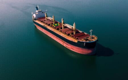 Shipping cargo to harbor by ship. Water transport International. Aerial view