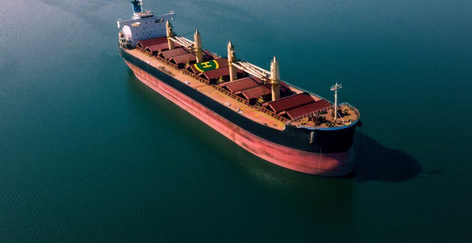 Shipping cargo to harbor by ship. Water transport International. Aerial view
